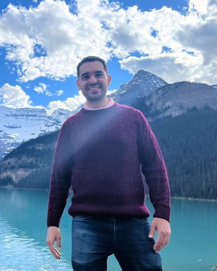 Aris, founder of Keep Learning Labs, smiling in front of a mountain lake